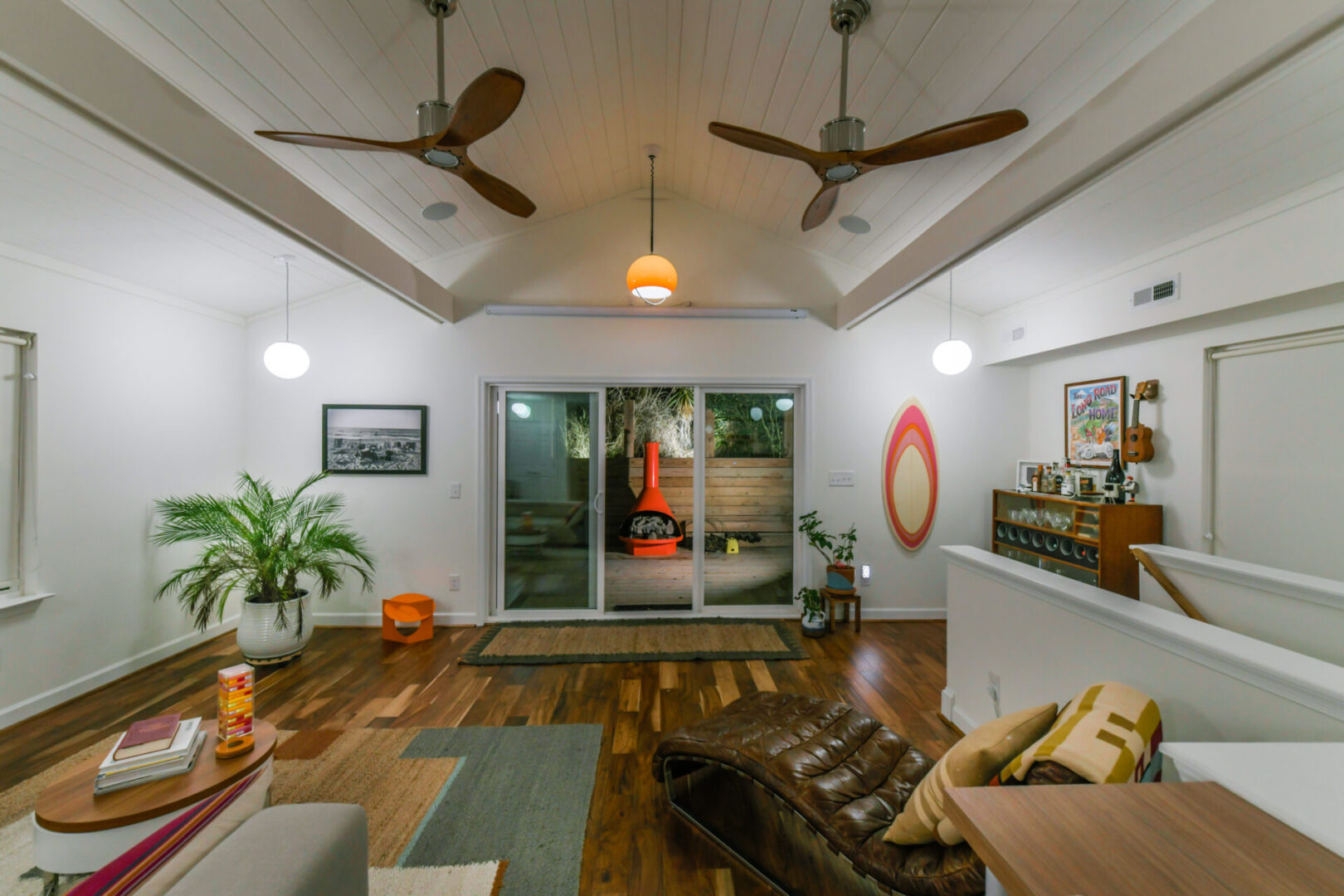 A living room with hard wood floors and ceiling fans.