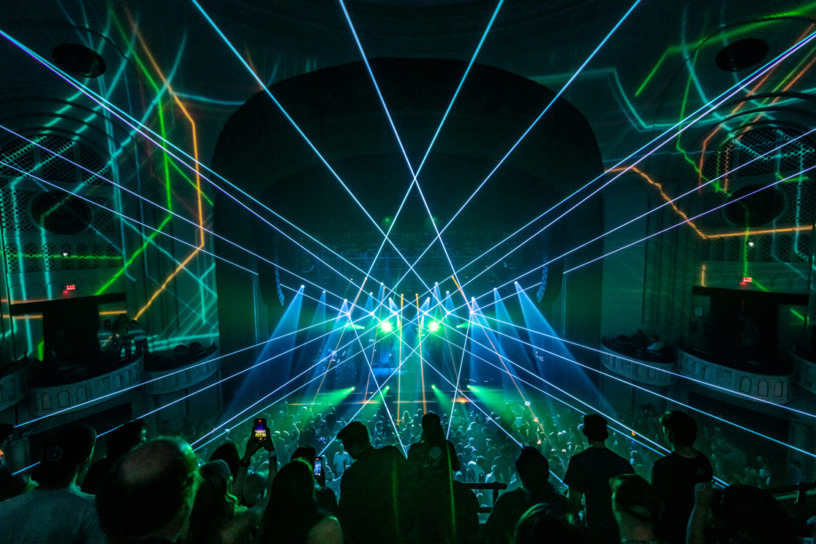 A crowd of people watching a laser light show.