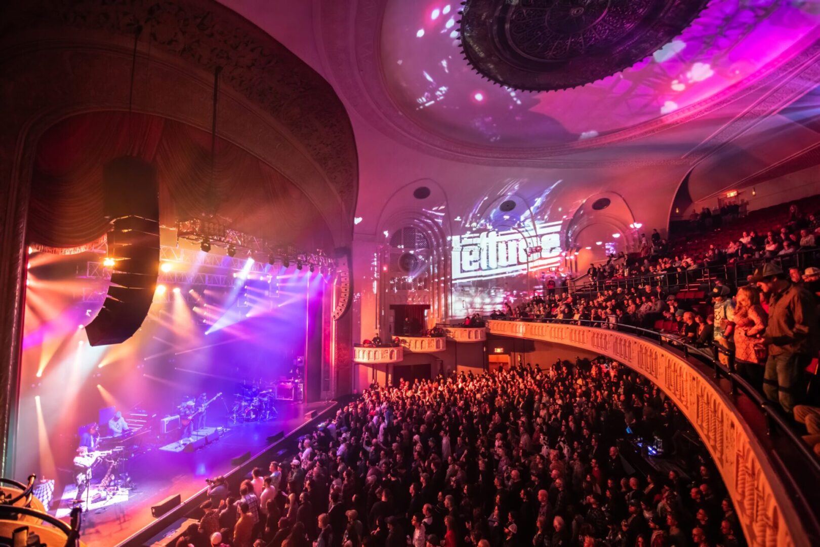 A large auditorium filled with people watching a concert.
