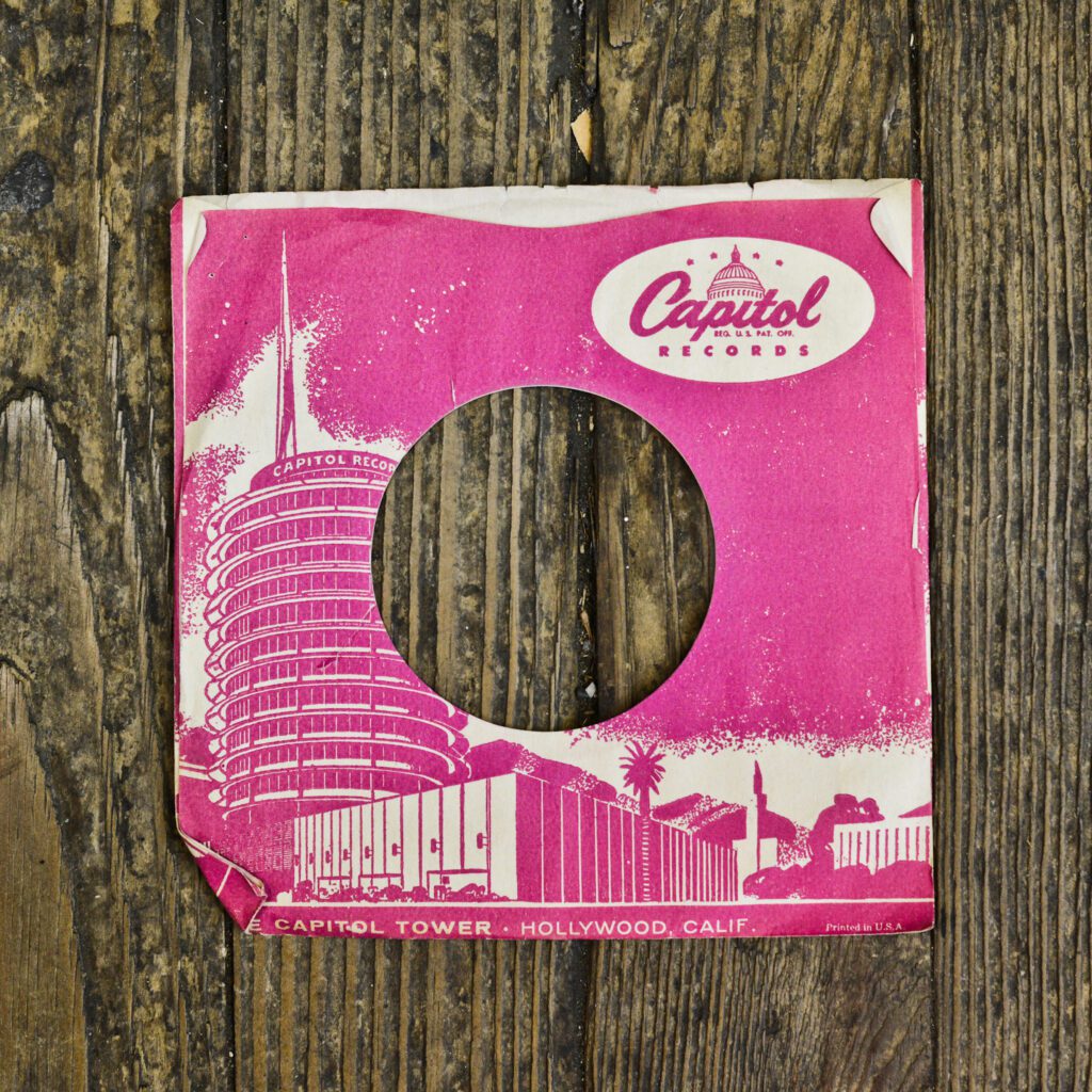 A pink record cover sitting on top of a wooden table.