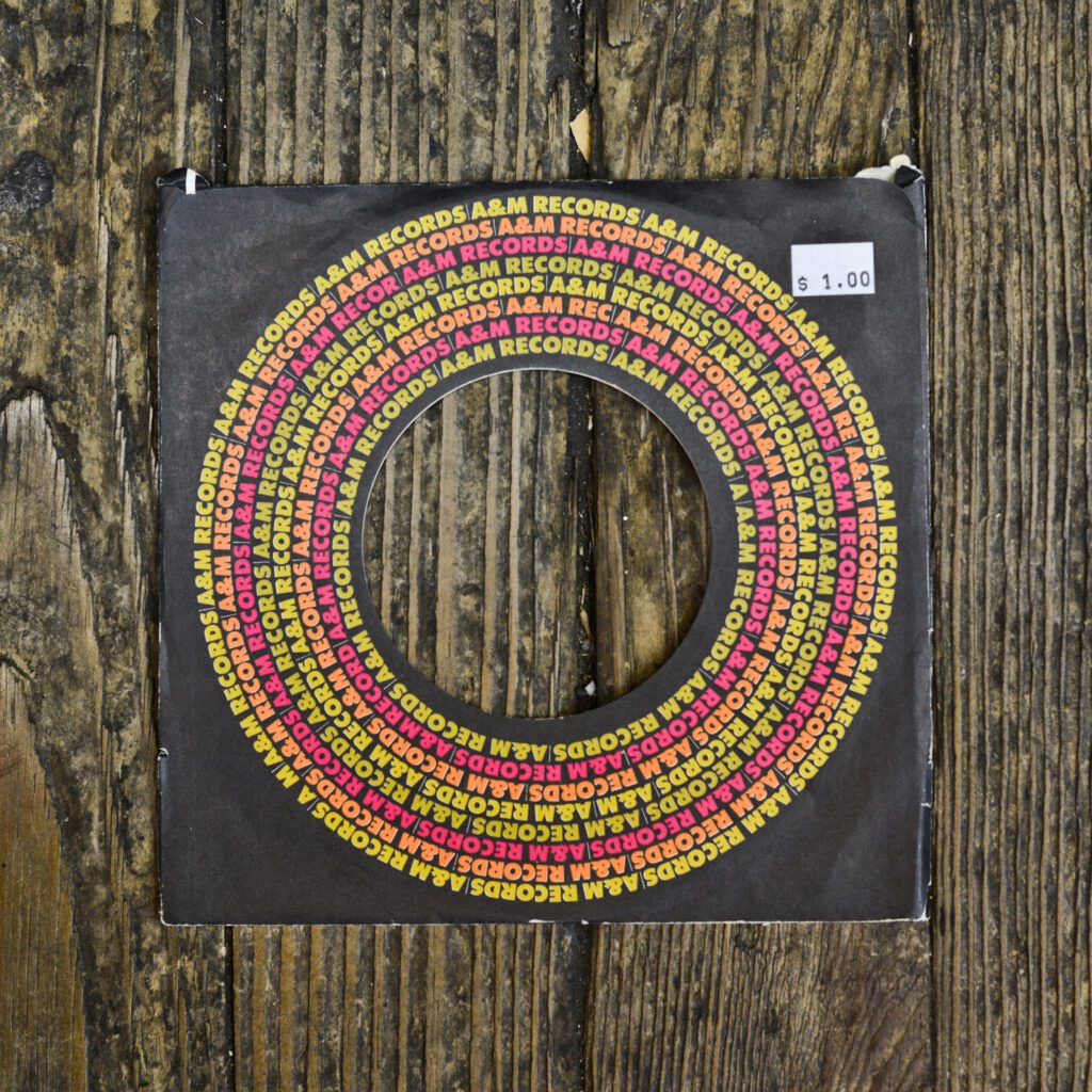 A wooden wall with a circle of yellow and red beads.
