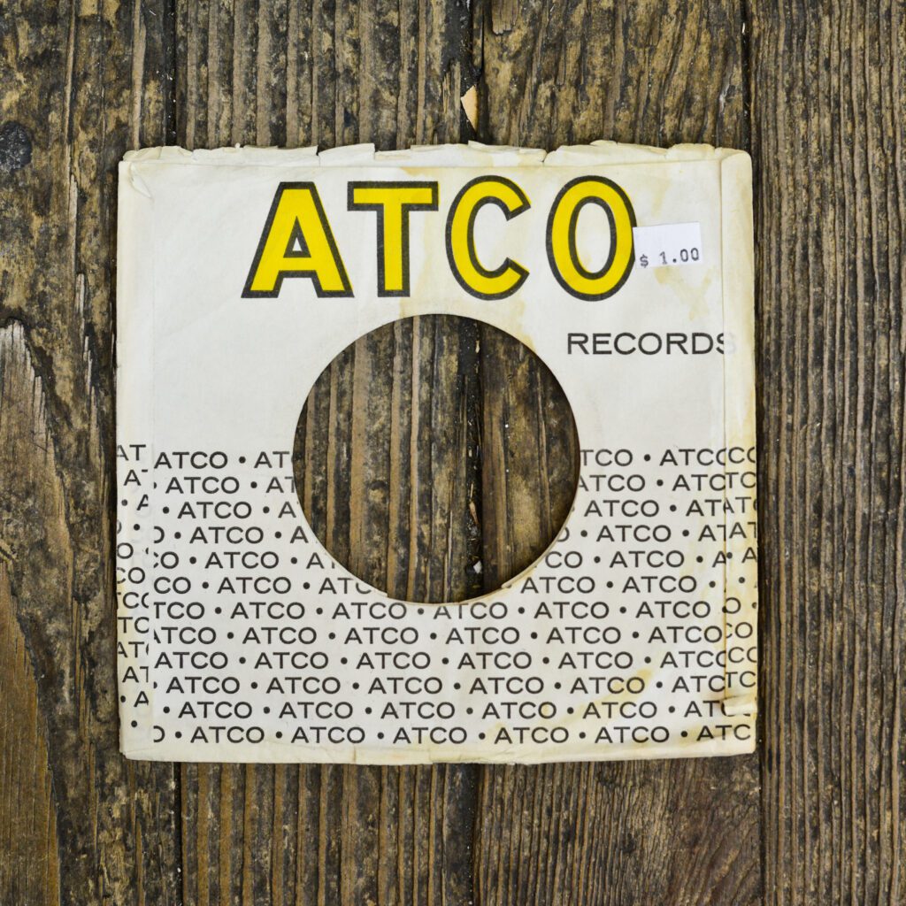 A white and yellow record label on the side of a wooden wall.