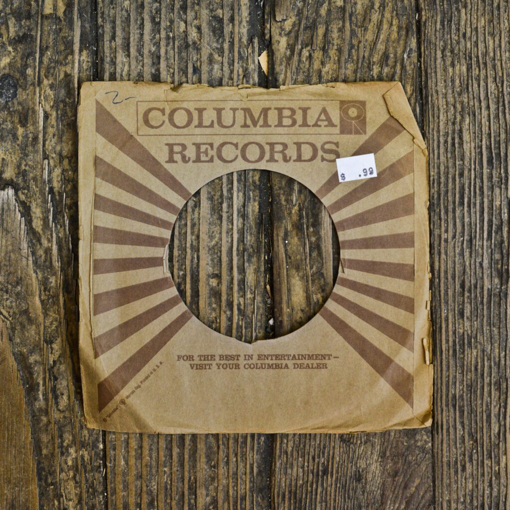 A cardboard record cover sitting on top of a wooden floor.