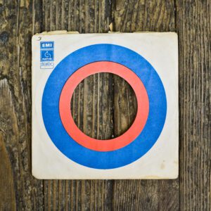 A wooden board with an orange and blue circle on it.