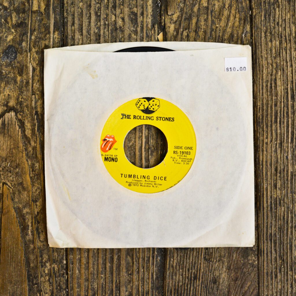 A yellow record sitting on top of a wooden table.