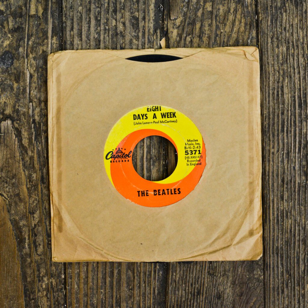 A yellow and orange record on top of a wooden table.