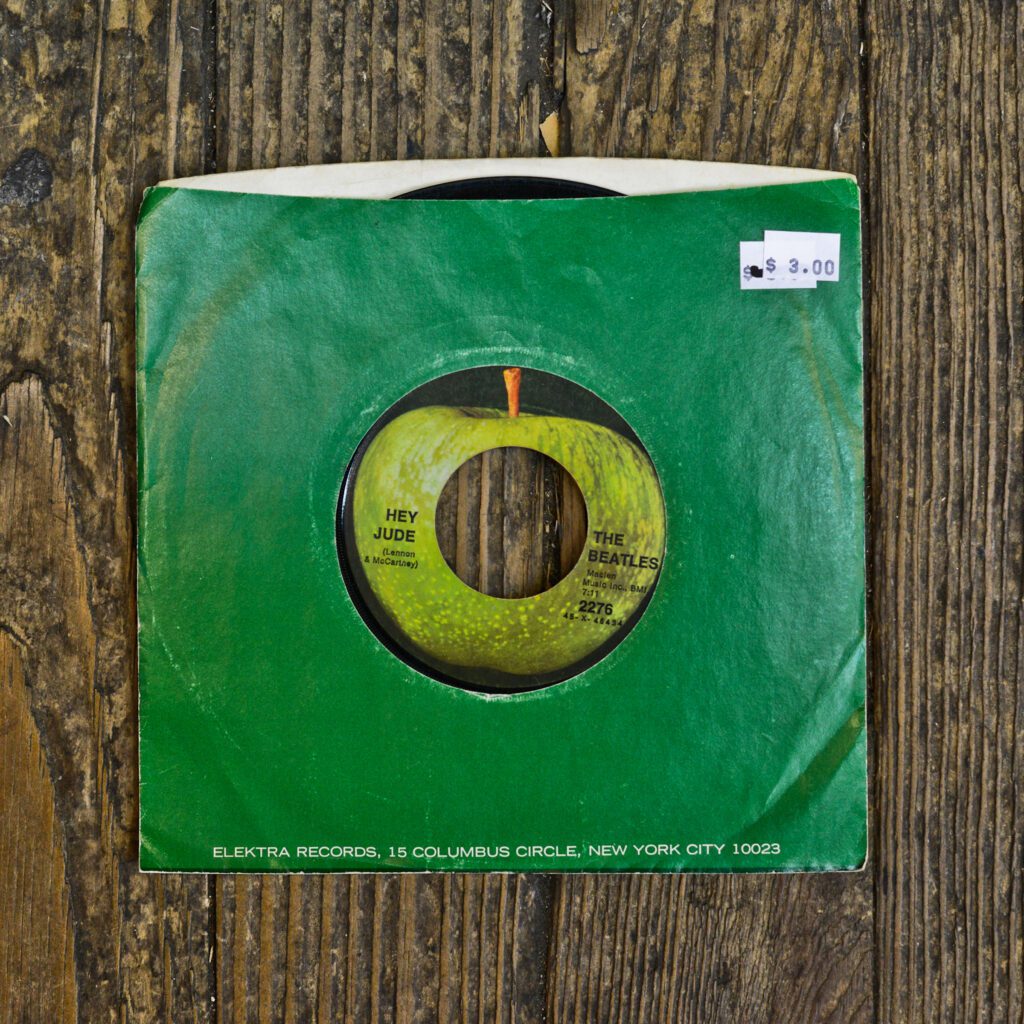 A green paper bag with a record on it.