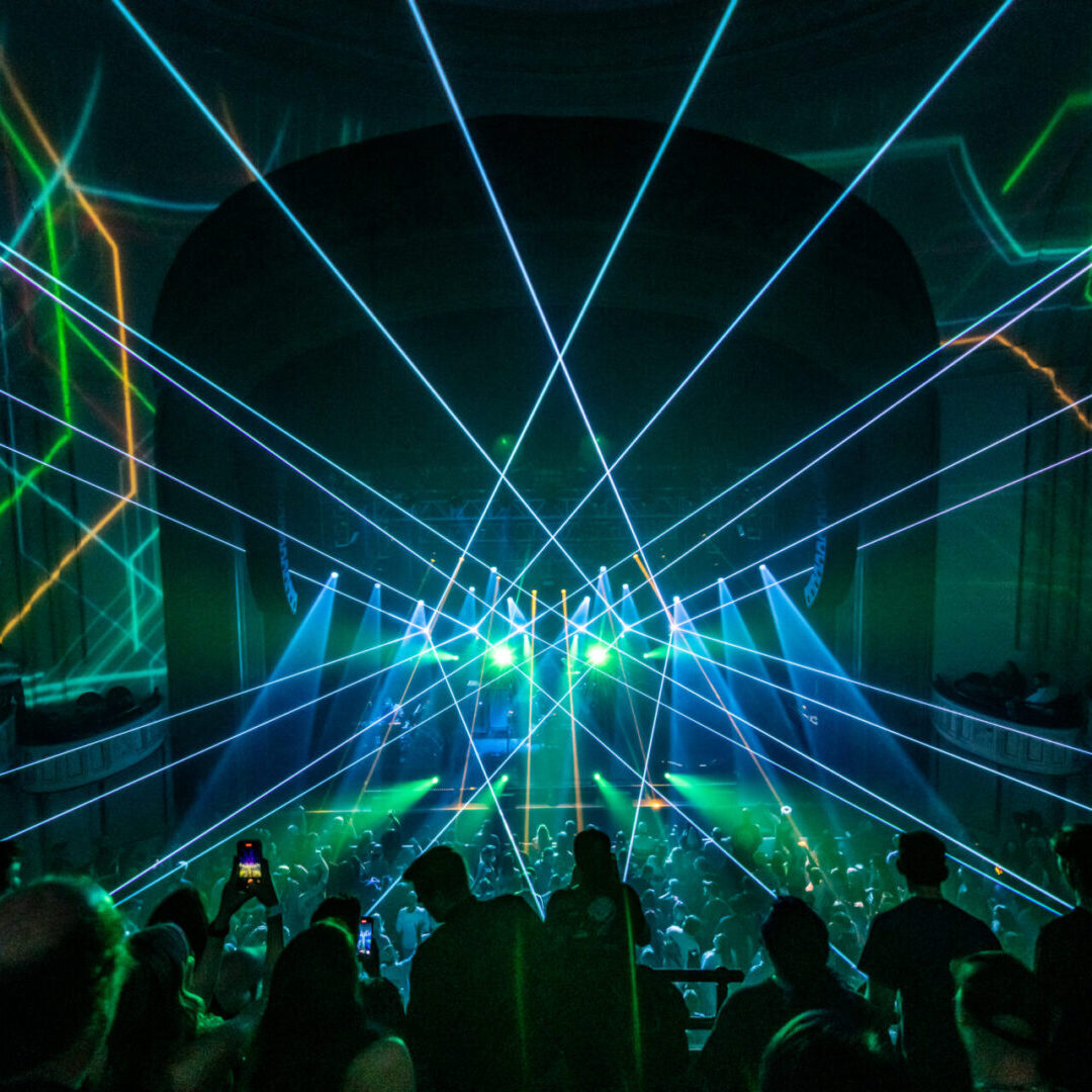 A crowd of people watching a laser light show.